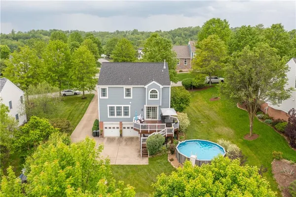 an aerial view of a house with garden space and a lake view
