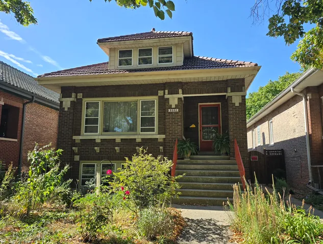 a front view of a house with a garden