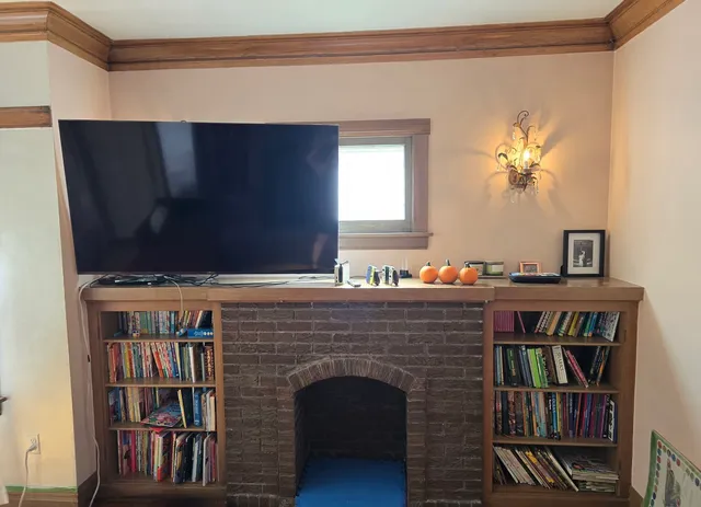 a living room with a bookshelf and a fireplace