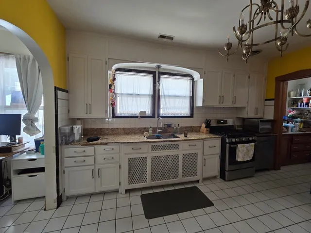 a kitchen with a stove sink and cabinets