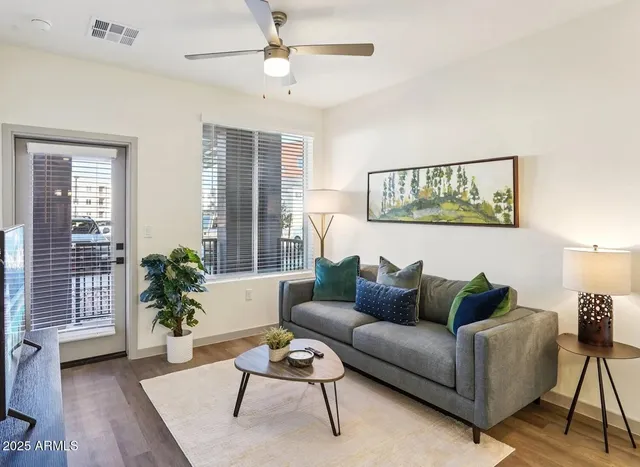 a living room with furniture potted plant and window