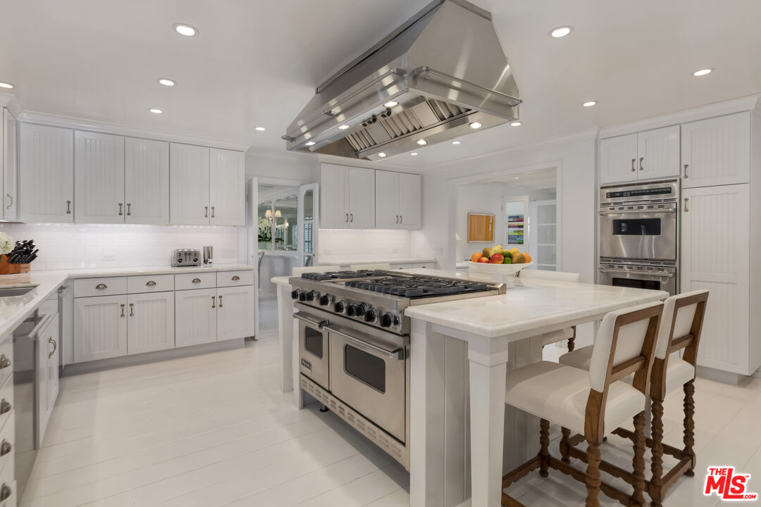 23430 Malibu Colony Road, Unit 95 Malibu, CA 90265 - Photo 18 of 35 a kitchen that has a lot of white cabinets and stainless steel appliances