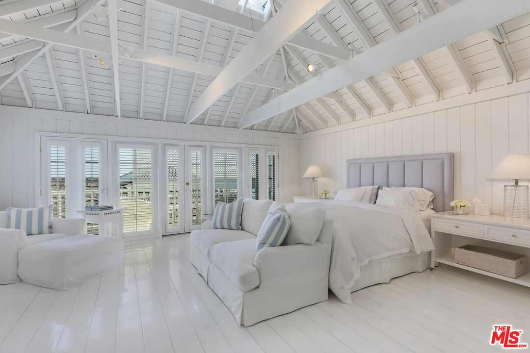23430 Malibu Colony Road, Unit 95 Malibu, CA 90265 - Photo 24 of 35 a spacious bedroom with a bed a couch and chandelier