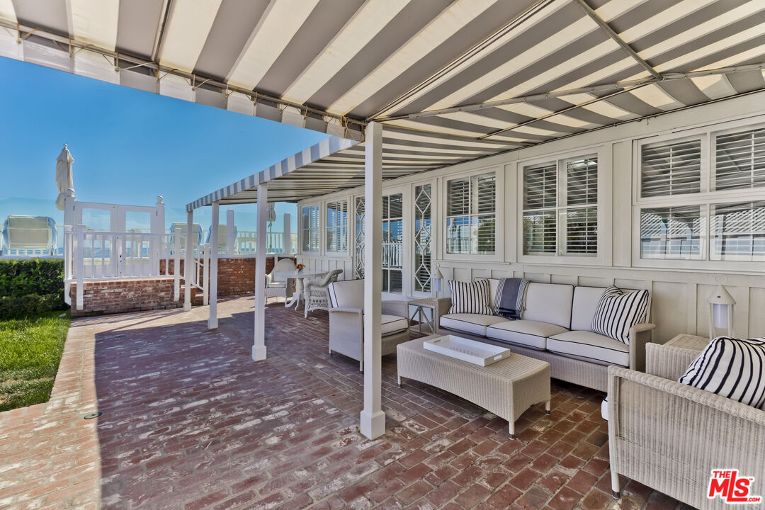 23430 Malibu Colony Road, Unit 95 Malibu, CA 90265 - Photo 10 of 35 a outdoor living space with furniture and a black umbrella