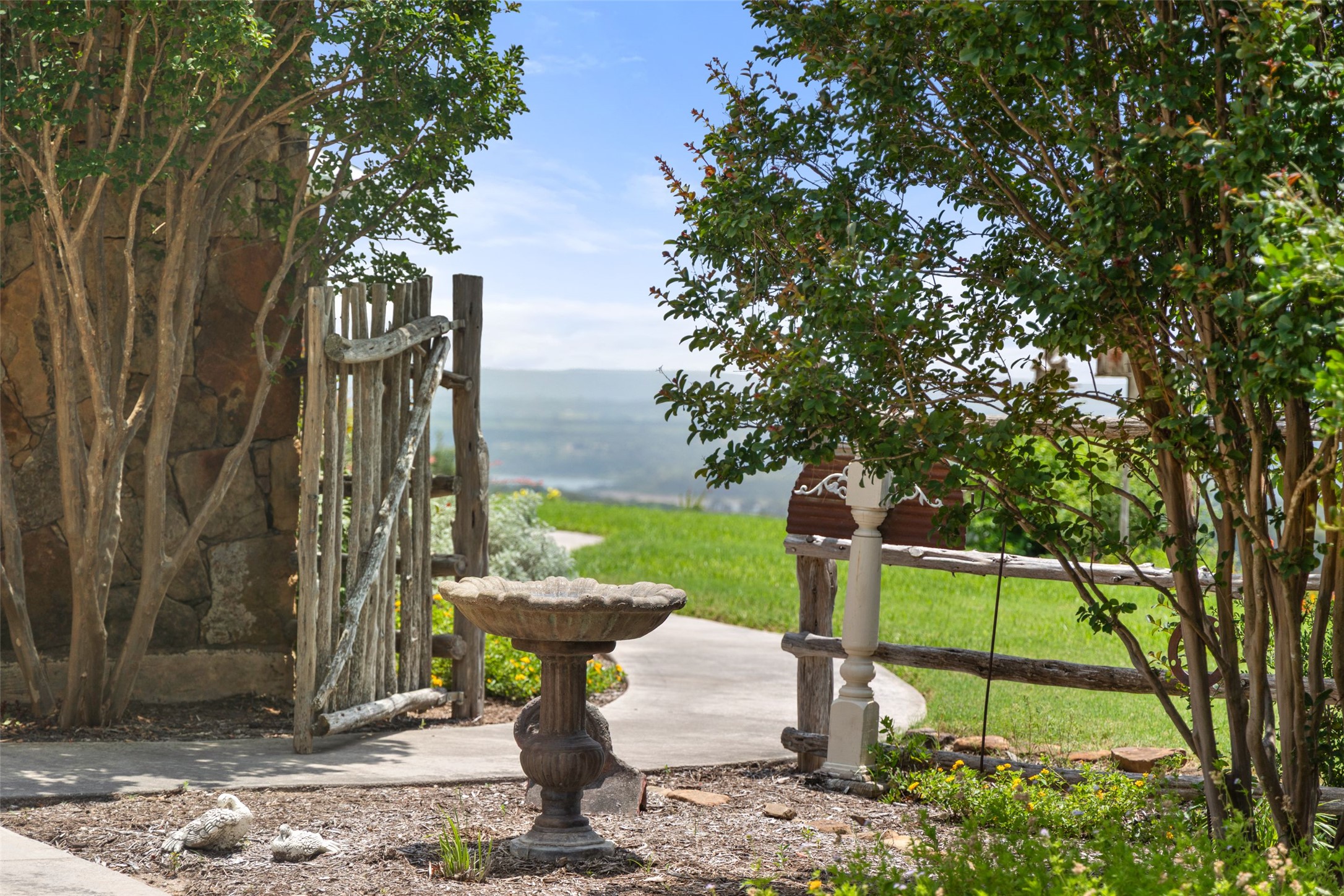 8400 Ranch Road 1431 Marble Falls, TX 78654 - Photo 8 of 30 A charming bird bath and rustic gate invite discovery of sweeping landscape views beyond.