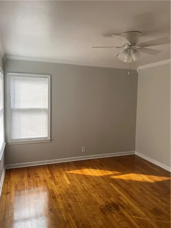 an empty room with a window and wooden floor