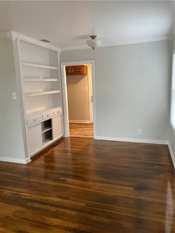 a view of empty room with wooden floor and fireplace
