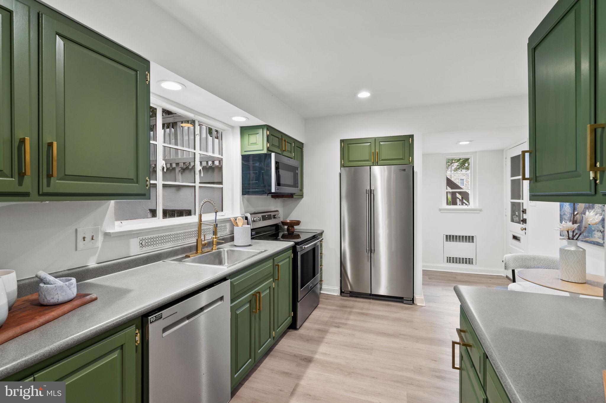 3937 Netherfield Road Philadelphia, PA 19129 - Photo 32 of 84 a kitchen with stainless steel appliances granite countertop a sink stove and refrigerator