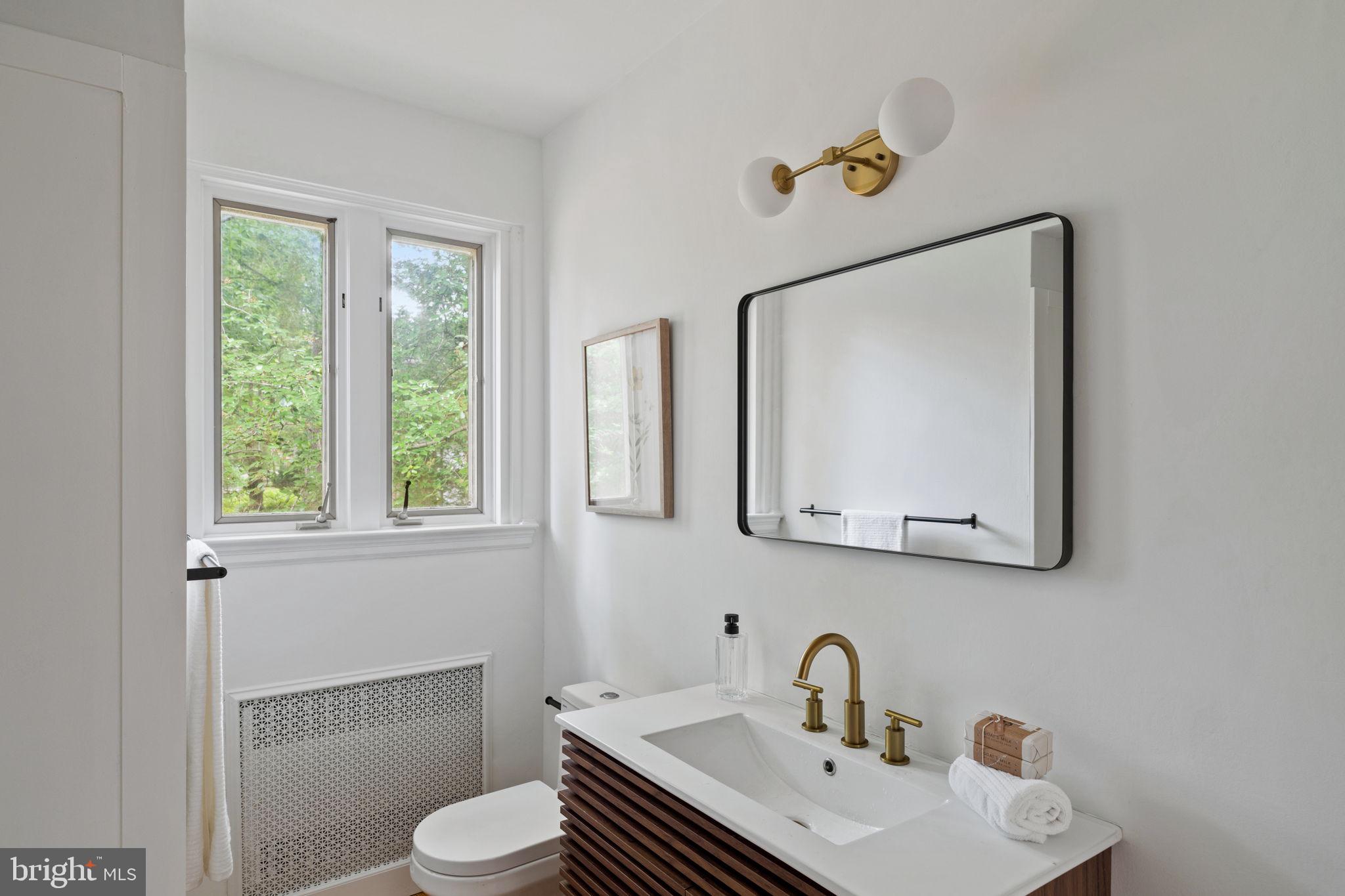 3937 Netherfield Road Philadelphia, PA 19129 - Photo 46 of 84 a bathroom with a toilet sink and mirror
