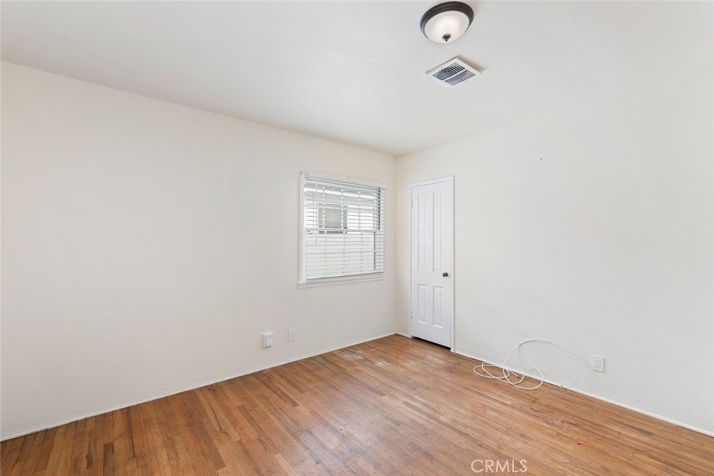 5663 Osburn Place Riverside, CA 92506 - Photo 15 of 38 an empty room with wooden floor and windows