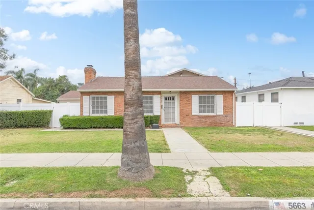 a front view of a house with a garden and yard