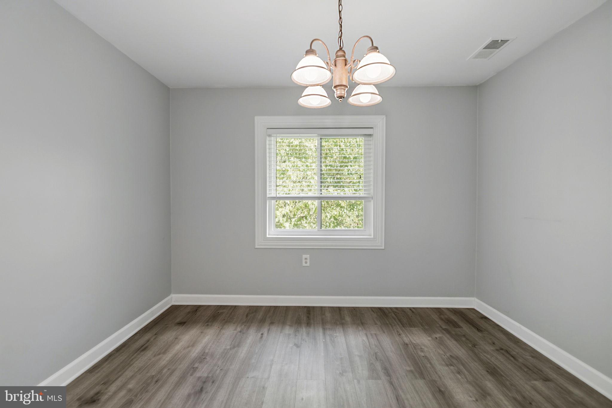 1443 Northgate Square, Unit 22B Reston, VA 20190 - Photo 7 of 42 a view of an empty room with wooden floor and a window