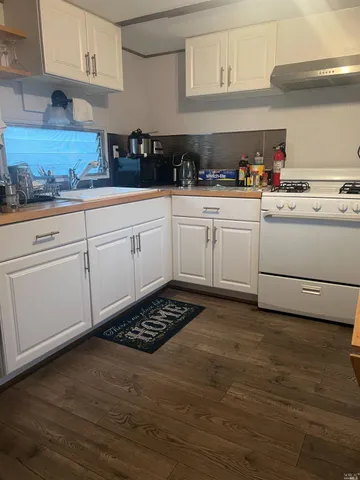 a kitchen with white cabinets and white appliances