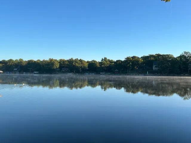 a view of a lake in between two trees