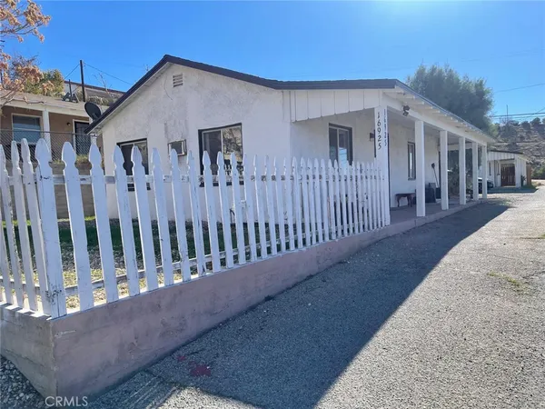 a view of a house with wooden fence