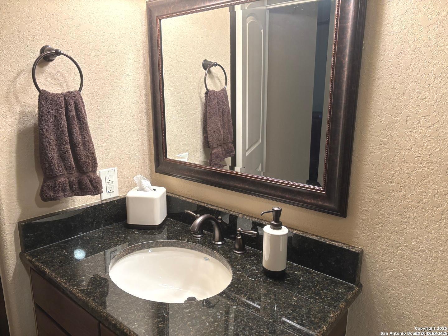 104 Park View Poth, TX 78147 - Photo 26 of 54 a bathroom with a granite countertop sink and a mirror