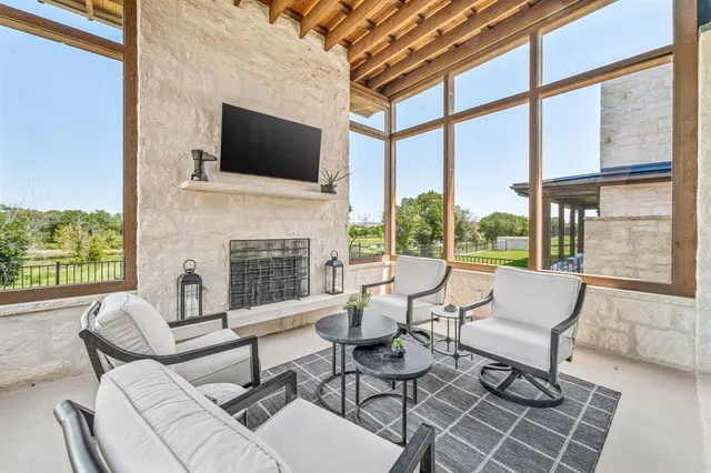 a living room with patio fireplace furniture and a flat screen tv