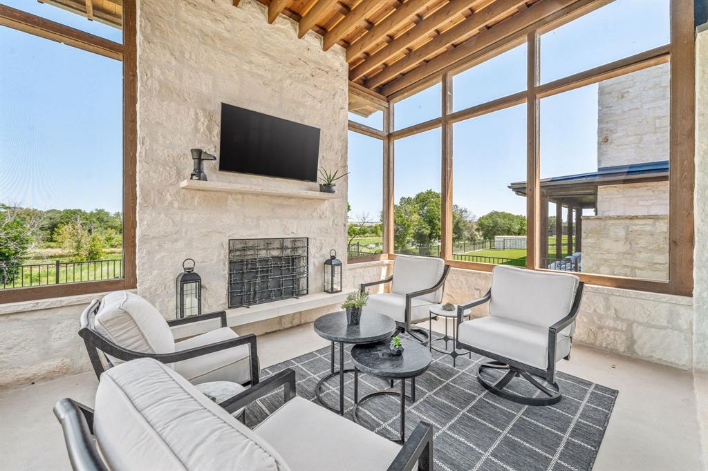 a living room with patio fireplace furniture and a flat screen tv