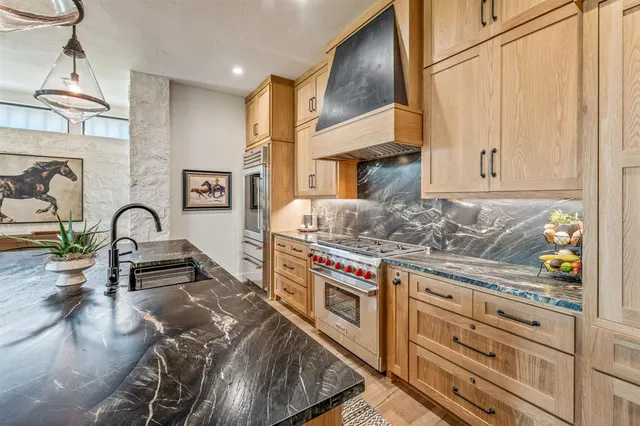 a kitchen with stainless steel appliances granite countertop a stove and a sink