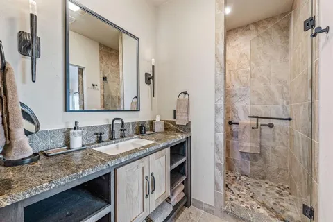 a bathroom with a granite countertop sink and a mirror
