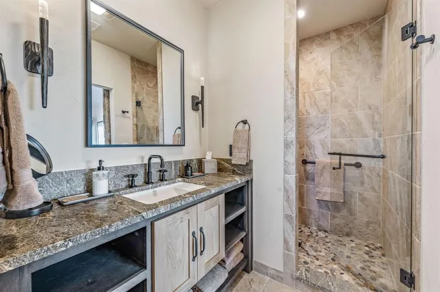 a bathroom with a granite countertop sink and a mirror