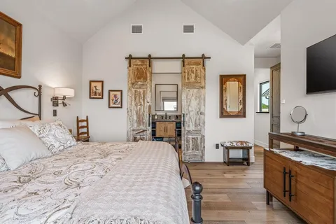 a bedroom with a bed and flat screen tv