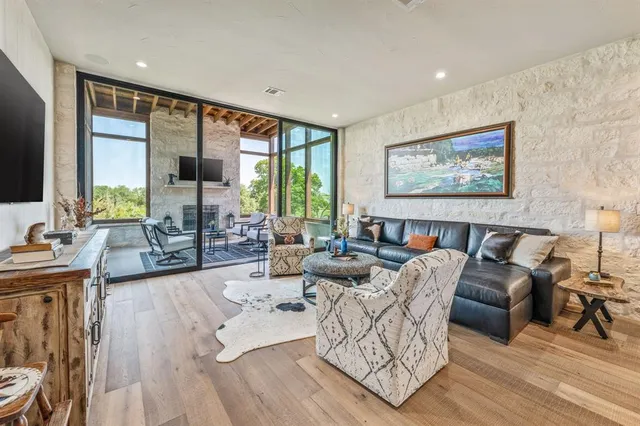 a living room with furniture large window and a wooden floor