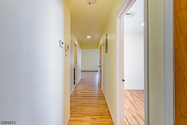a view of a hallway with wooden floor