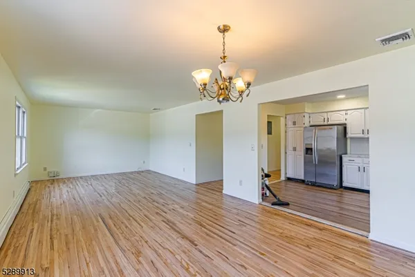 a view of livingroom with chandelier and wooden floor