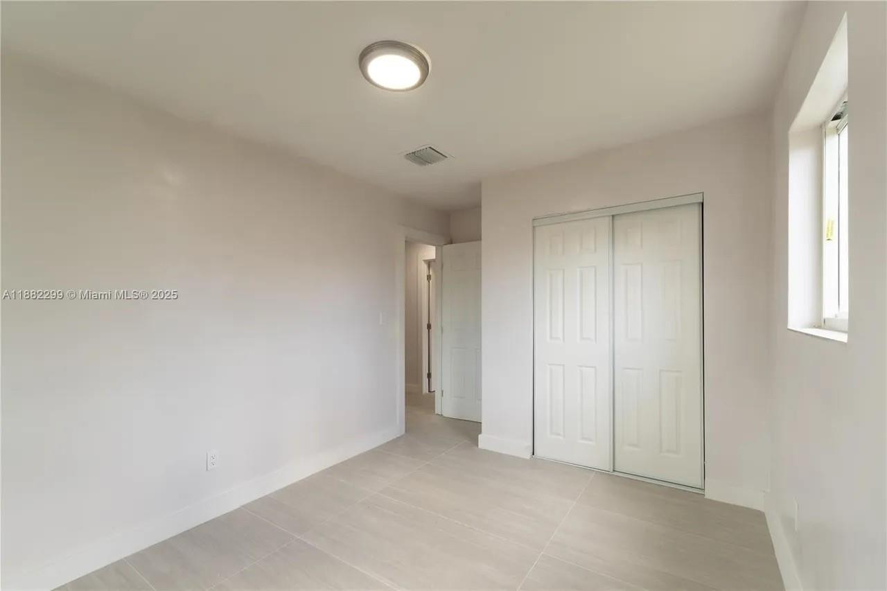 11872 Southwest 196th Terrace Miami, FL 33177 - Photo 12 of 15 an empty room with windows and closet