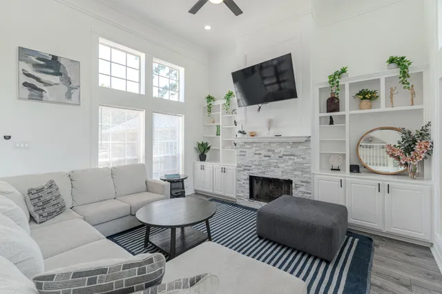 a living room with furniture a flat screen tv and a fireplace