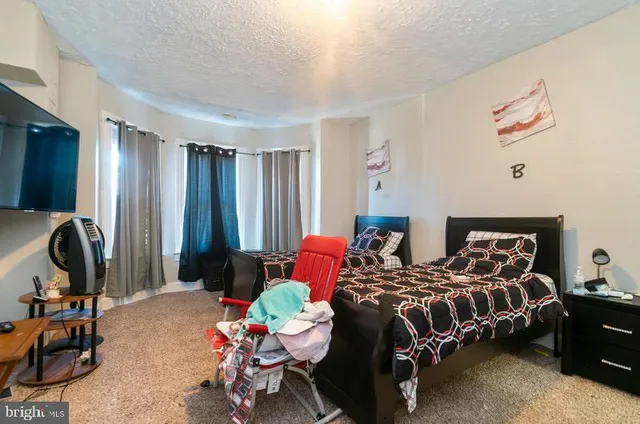 a bedroom with bed and a flat tv screen