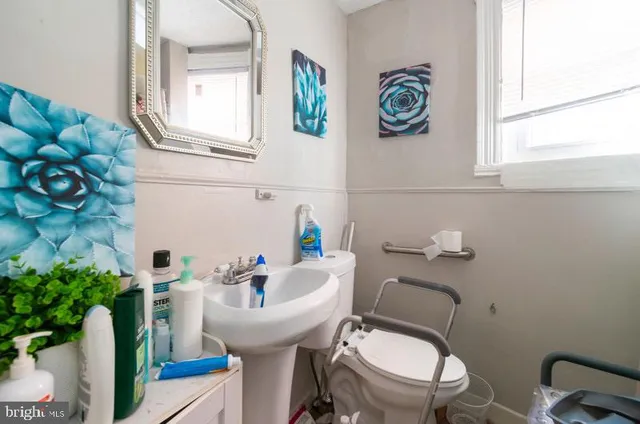 a bathroom with a sink vanity mirror and toilet