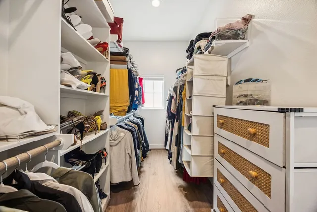 a view of walk in closet with clothes and shoes
