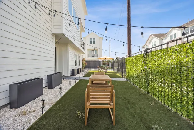 a view of a patio with table and chairs with wooden floor and fence