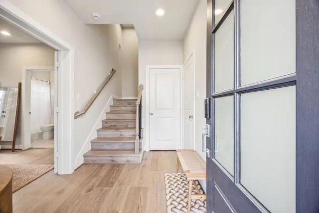 a view of hallway with wooden floor and stairs