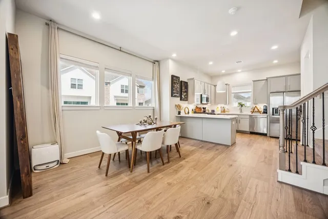 a kitchen with a table chairs refrigerator and cabinets