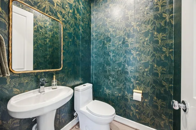 a bathroom with a toilet sink and mirror