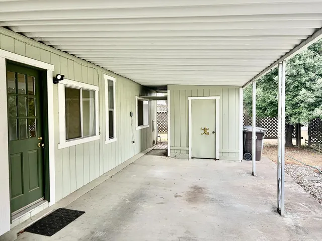 a view of a porch with wooden floor and fence