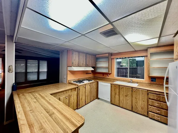 a kitchen with stainless steel appliances granite countertop a sink window and cabinets