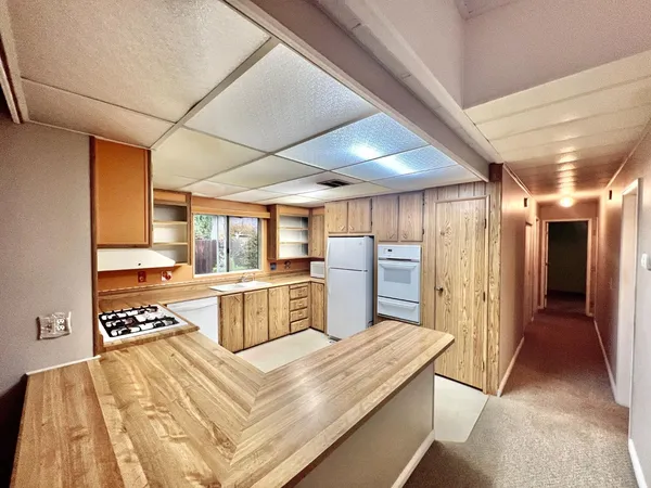 a large kitchen with a large window and stainless steel appliances