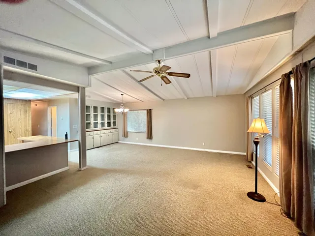 a view of a livingroom with a ceiling fan and window