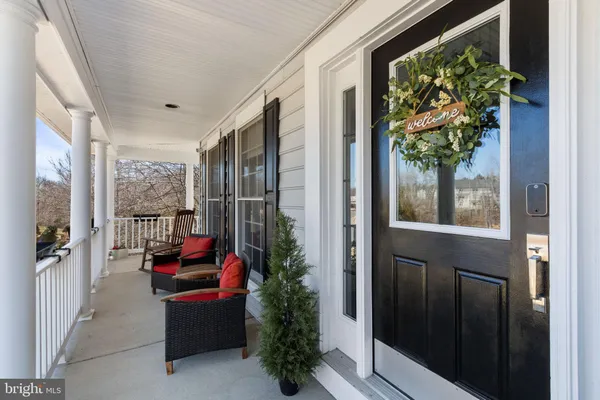 a porch with chairs and potted plants