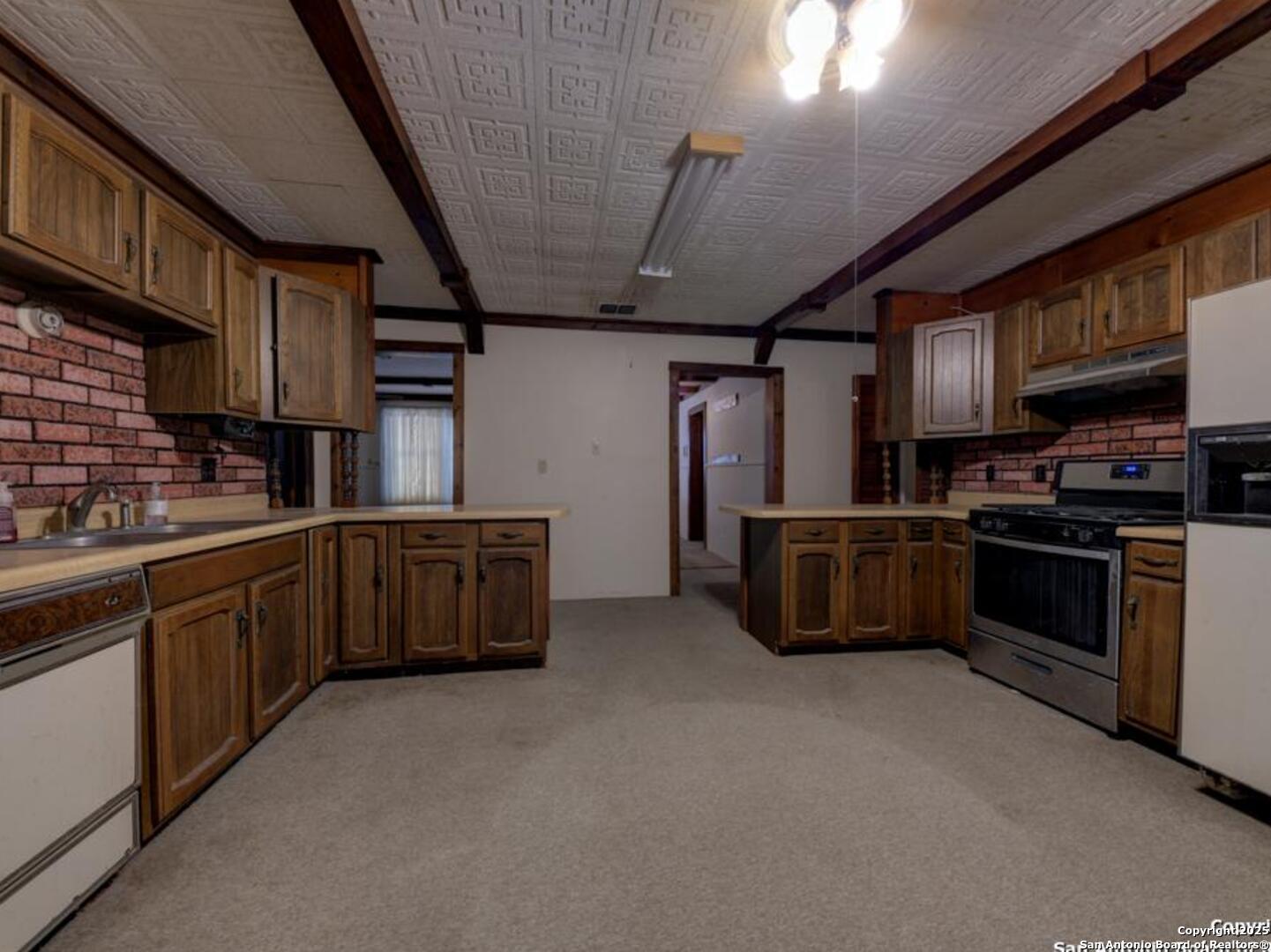 137 Kitty Hawk Road Universal City, TX 78148 - Photo 12 of 25 a kitchen with stainless steel appliances wooden cabinets and a sink