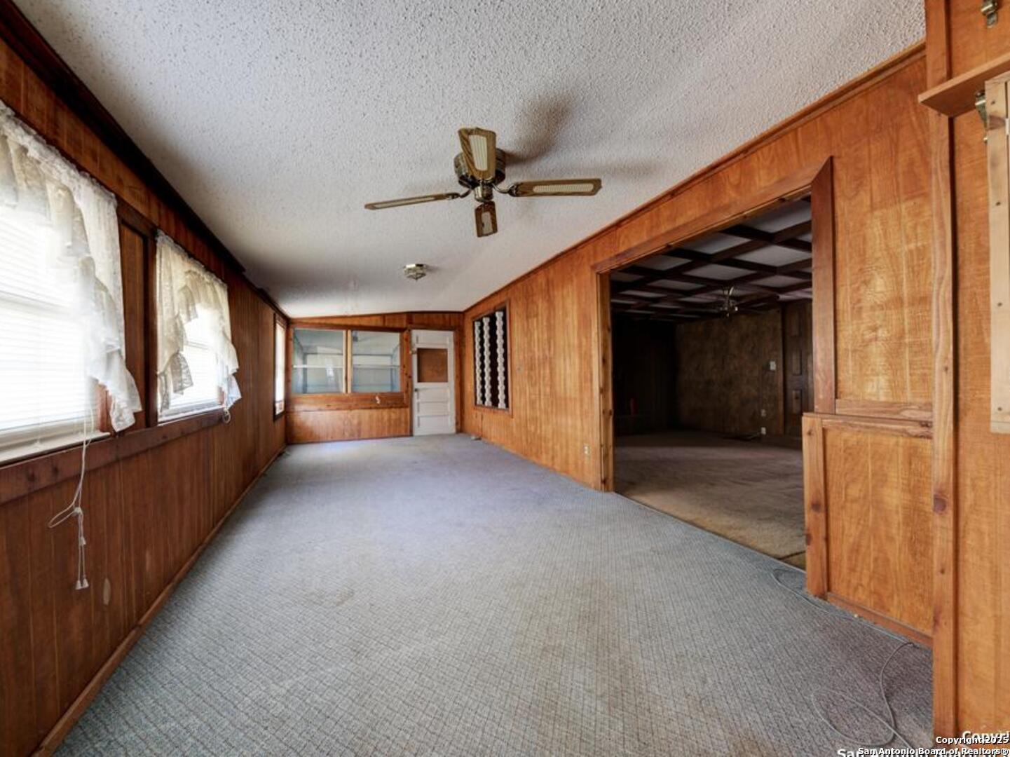 137 Kitty Hawk Road Universal City, TX 78148 - Photo 13 of 25 a view of a livingroom with wooden floor and a ceiling fan