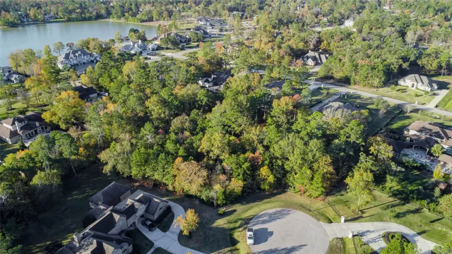 an aerial view of a house with a yard and lake view
