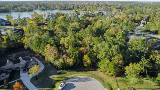 an aerial view of a house with a yard and lake view