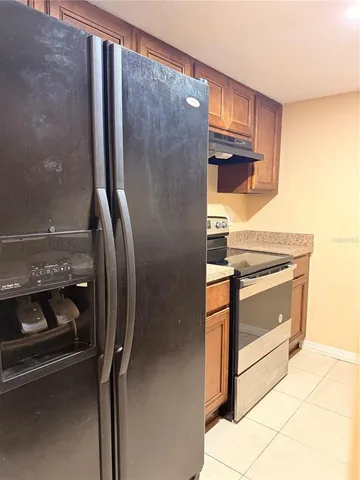 a kitchen with a refrigerator and white cabinets