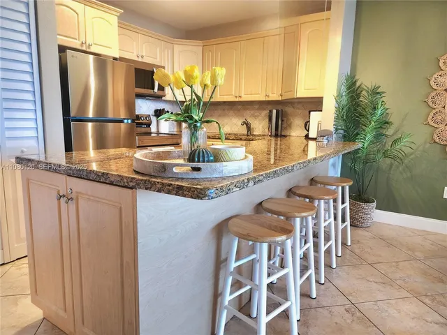 a kitchen with stainless steel appliances granite countertop a sink and a refrigerator