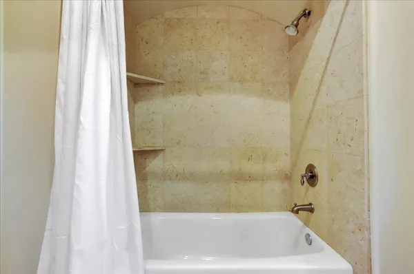 a living room with furniture kitchen view and a wooden floor